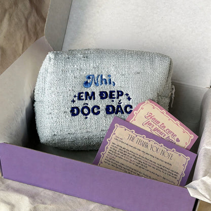 Ảnh thật – Tweed Pouch xanh dương thêu tên Nhi và quote Em Đẹp Độc Đắc trong hộp quà Dear eM